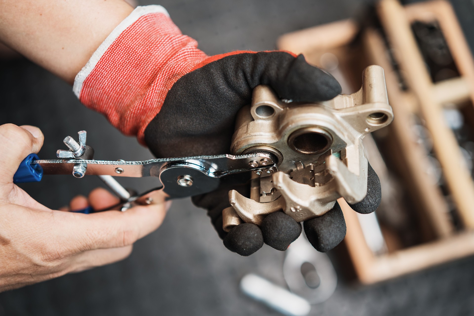 Mechanic remove a seized brake caliper piston with motorcycle caliper piston removal tool in garage, maintenance and repair concept